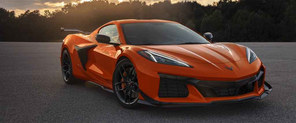 Orange Chevrolet Corvette Z06 parked on an open road at sunset.
